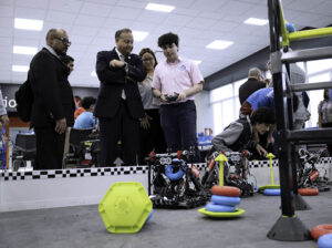 Caguas Mayor William Miranda-Torres watches a student operate a remote-controlled robot during the opening of the LIFT Learning Lab.