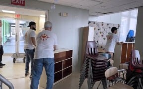 Volunteers move furniture donated by St. John's school.