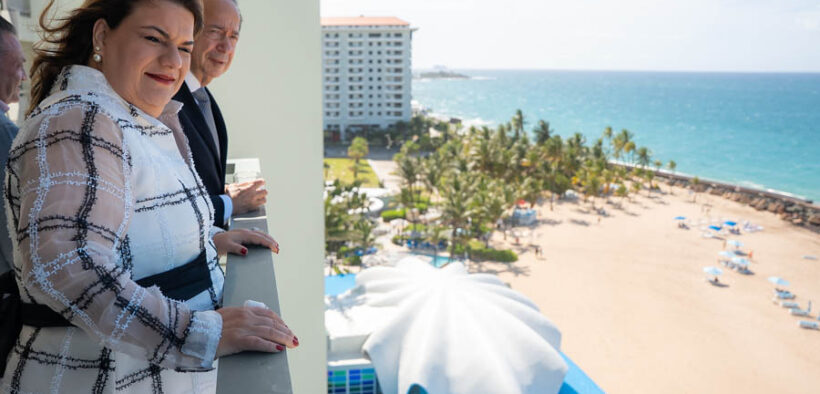 Businessman John Paulson and Puerto Rico Gov. Jenniffer González overlook the beach and iconic seashell-shaped structure at La Concha Resort in San Juan.