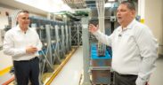 From left, Chuck Page, Liberty vice president of technical operations, and Víctor Vera, engineering director for Puerto Rico and the U.S. Virgin Islands, stand in front of backup batteries at the company’s core platform site in San Juan.