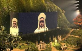 Bad Bunny’s image appears on a massive screen as performers dressed in traditional jíbaro clothing take the stage during his “No me quiero ir de aquí” concert residency in San Juan.
