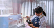A worker pours steamed milk at Indulac’s facility in Puerto Rico, where the cooperative produces shelf-stable dairy products for local and export markets.