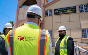 Catholic Extension Society staff meets with Father Josué E. Colón-Claudio in front of the Parroquia y Santuario San Martín de Porres in Arecibo, one of the churches undergoing restoration.