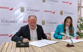 Willianette Robles, head of the Puerto Rico Tourism Office, and Víctor Moneo of Iberia sign the new agreement.