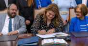Gov. Jenniffer González signs a measure alongside members of her cabinet