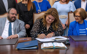 Gov. Jenniffer González signs a measure alongside members of her cabinet