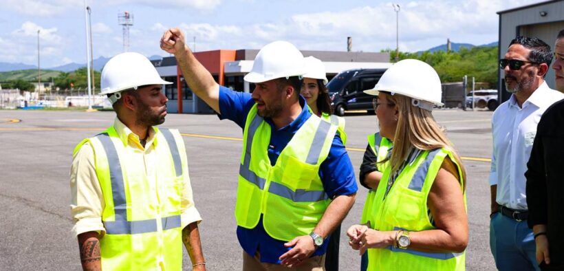Ports Authority Executive Director Norberto Negrón, center, walks through the airport facilities with employees.