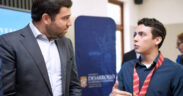 Sebastián Negrón-Reichard, secretary of the Department of Economic Development and Commerce, speaks with a student involved in developing the Interactive Map of Puerto Rico’s Logistics and Cargo Ecosystem.
