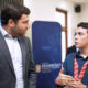 Sebastián Negrón-Reichard, secretary of the Department of Economic Development and Commerce, speaks with a student involved in developing the Interactive Map of Puerto Rico’s Logistics and Cargo Ecosystem.