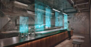 A bartender manages a futuristic bar using a holographic interface to streamline service in a modern, technology-driven establishment. (Credit: Justlight | Dreamstime.com)