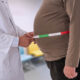 A physician measures a patient’s waistline as rising obesity rates in Puerto Rico drive higher cancer risks and add strain on the health care system. (Credit: Jean Paul Chassenet | Dreamstime.com)