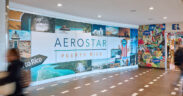 Travelers pass a colorful Aerostar display at Luis Muñoz Marín International Airport in Carolina, Puerto Rico, where 2025 court rulings upheld Airport Shoppes’ exclusive food and beverage rights in its dispute with airport operator Aerostar. (Credit: Discover Puerto Rico)