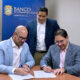 Josué E. Rivera, president of the Puerto Rico Economic Development Bank, stands as physicians Juan Nieves and Félix Álvarez sign a nearly $1.4 million loan agreement to expand Puerto Rico Cardiology LLC.